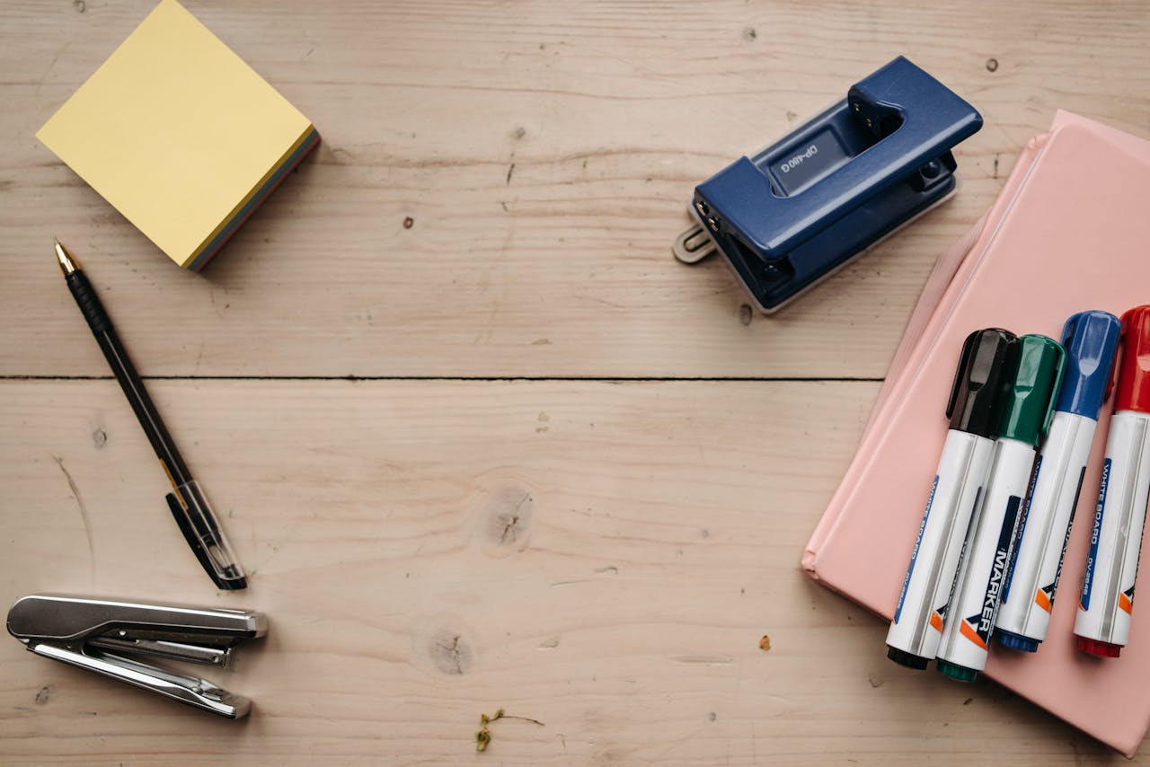 home-img Flat lay of office supplies on a wooden desk for a neat workspace setup.
