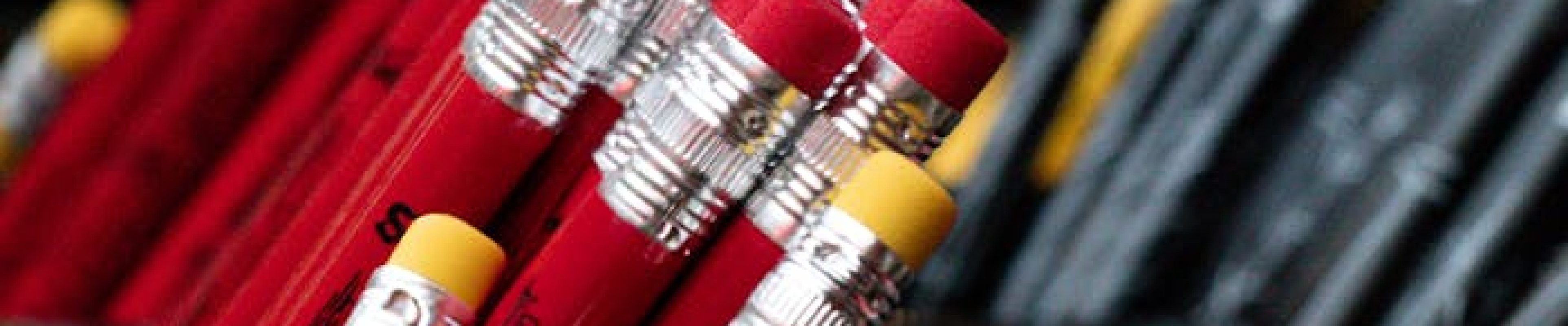 Close-up of red and yellow pencils in containers, offering vibrant stationery organization inspiration.